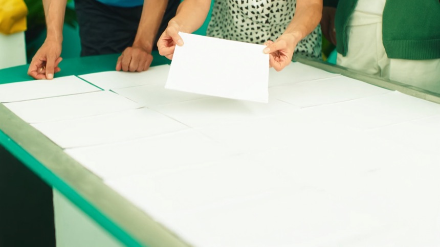 Manos ordenando hojas en blanco para estructurar un artículo de contenido SEO para pymes